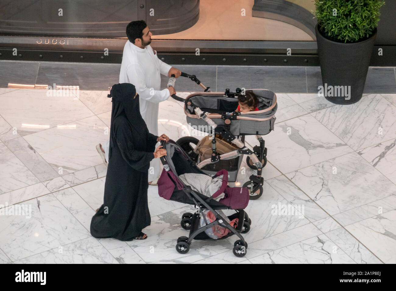 Couple arabe wheeling prams avec bébé, Centre Commercial de Dubaï, Émirats Arabes Unis Banque D'Images