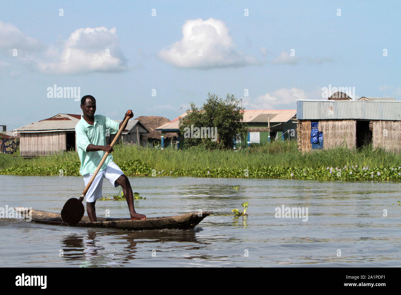 Béninois pagayant dans une pirogue. Cité lacustre sur le lac Nokoué. Ganvié. Bénin. Banque D'Images