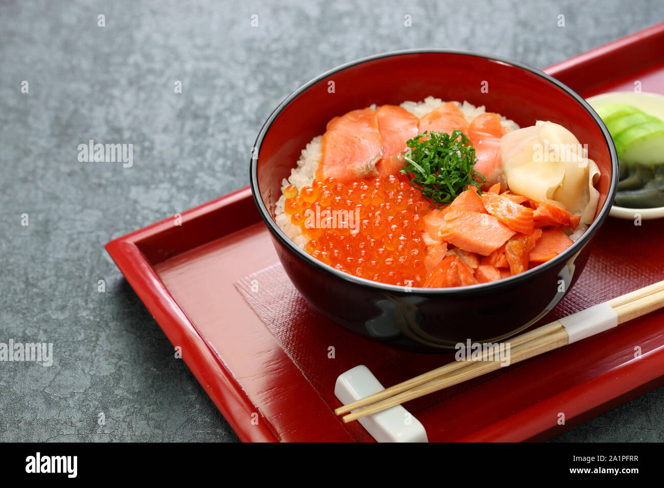 Bol de riz garni d'oeufs de saumon, du saumon et de la nourriture japonaise Banque D'Images