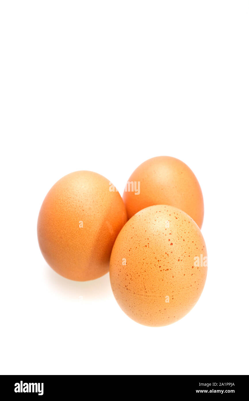 Trois oeufs brun isolé sur la surface blanche en orientation portrait Banque D'Images