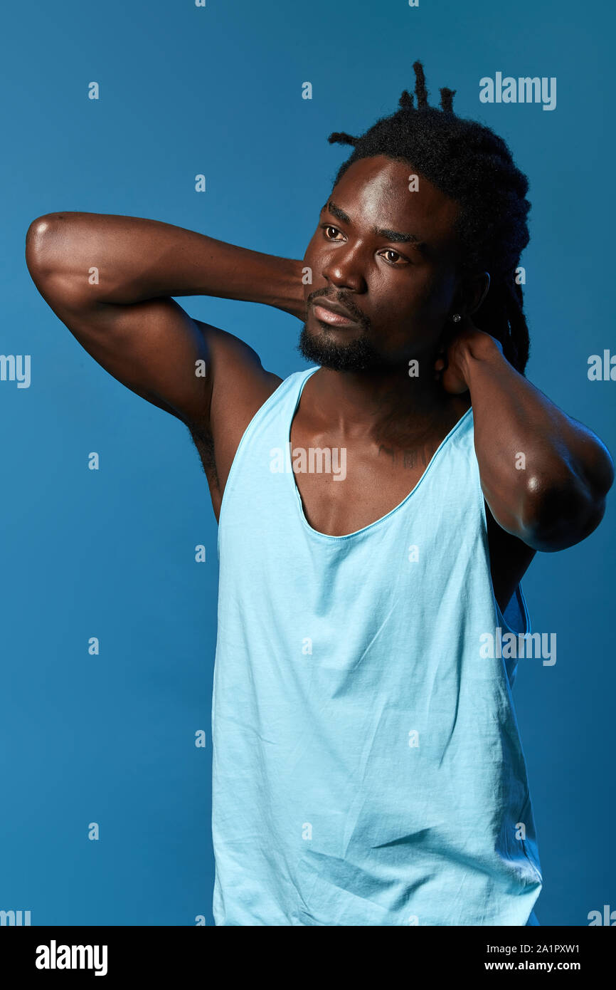 Bel homme fatigué endormi se réveiller le matin, les étirements , portrait, isolé blue background, studio shot Banque D'Images