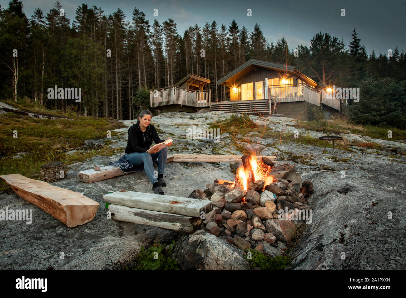 Femme lisant, feu de camp en Norvège Banque D'Images