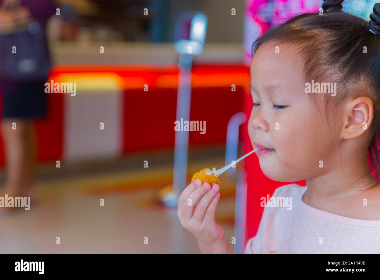 Petit enfant manger asiatique stretch collants boule de fromage frit. sensation de plaisir. Galerie d'images haute résolution. Banque D'Images