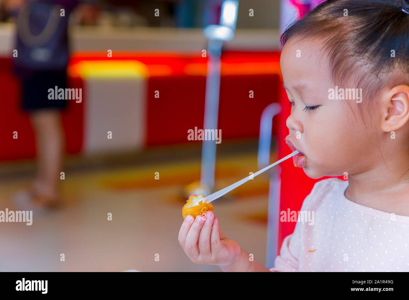 Petit enfant manger asiatique stretch collants boule de fromage frit. sensation de plaisir. Galerie d'images haute résolution. Banque D'Images
