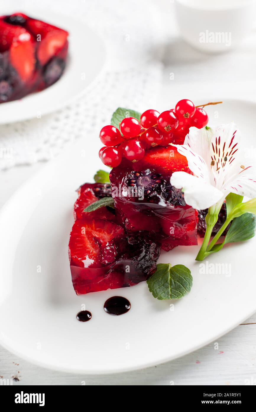 Terrine de gelée de fruits frais avec fraise, framboise, mûre et groseille rouge sur le tableau blanc Banque D'Images