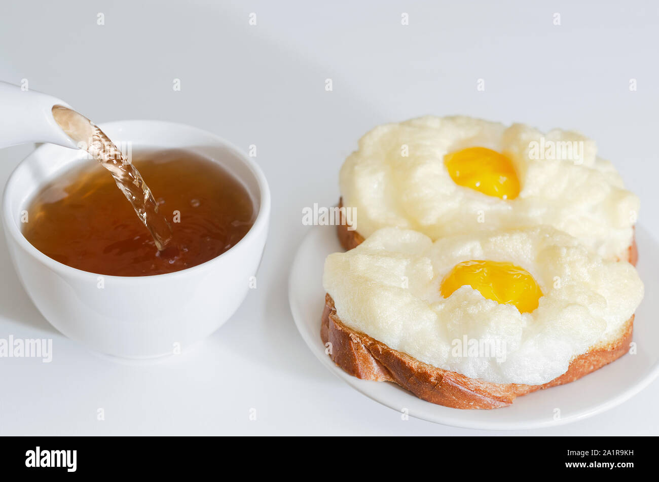 Chaud, sandwichs aux œufs cuits au four pour le petit-déjeuner. Verser dans une tasse de thé. Selective focus Banque D'Images