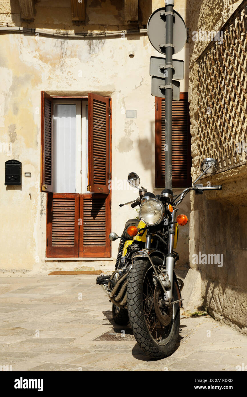 Vintage moto jaune debout dans la rue de la vieille ville italienne. Lecce, Pouilles, Italie Banque D'Images