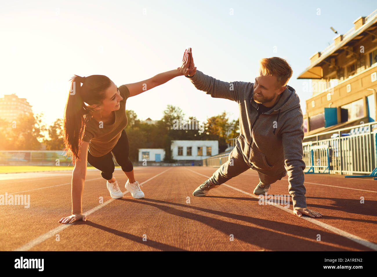 Jeune couple doing pushups dans le stade Banque D'Images