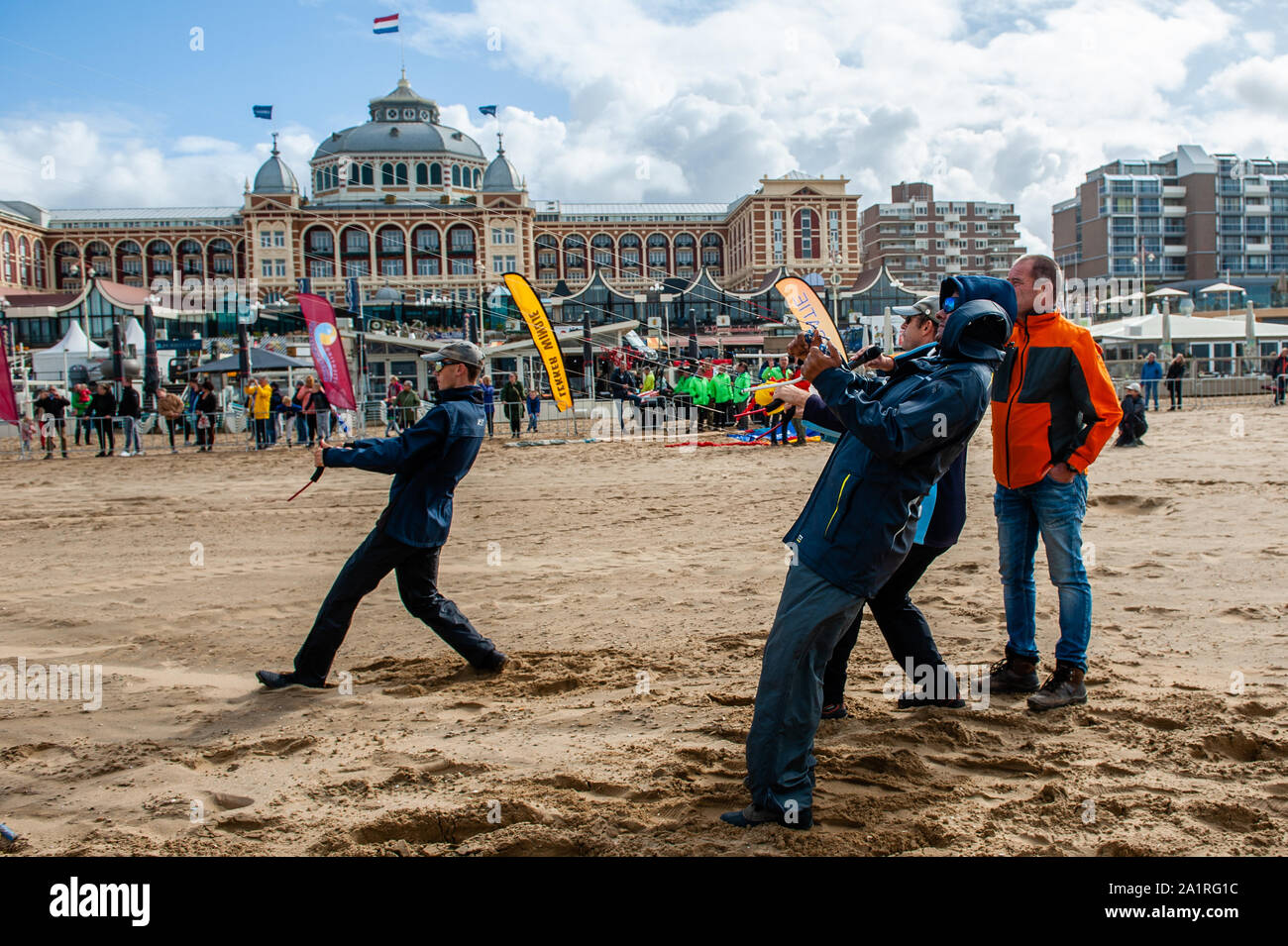 Les hommes avec des cerfs-volants sur la plage pendant le festival.Festival international de Cerf-volant Scheveningen, tire le meilleur parti de l'accord les vents dominants soufflant le long de La Haye's beach resort. Les constructeurs et les amateurs de cerfs-volants du monde entier se réunissent à voler le fruit de leur travail créatif. L'événement annuel voit le ciel au-dessus de la partie sud de la plage de Scheveningen se remplissent de cerfs-volants géants de toutes les formes et couleurs, battant les ours, les éléphants et les poissons. Les visiteurs peuvent également obtenir de rester à jour avec les dernières en kite-powered sport, du kite-surf et kite-yachting pour le kitesurf et la planche à roulettes kite- Banque D'Images