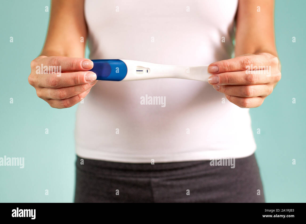 La fille tient dans sa main un test de grossesse positif. Le début de la grossesse. La preuve de la grossesse. Selective focus Banque D'Images