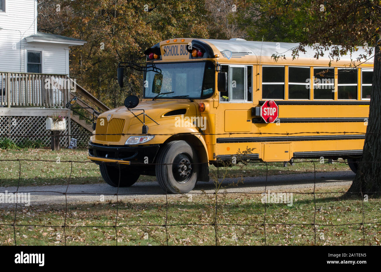 Un bus scolaire se trouve à l'extérieur d'une ferme, d'attente pour les enfants de sortir et de monter dans le bus Banque D'Images