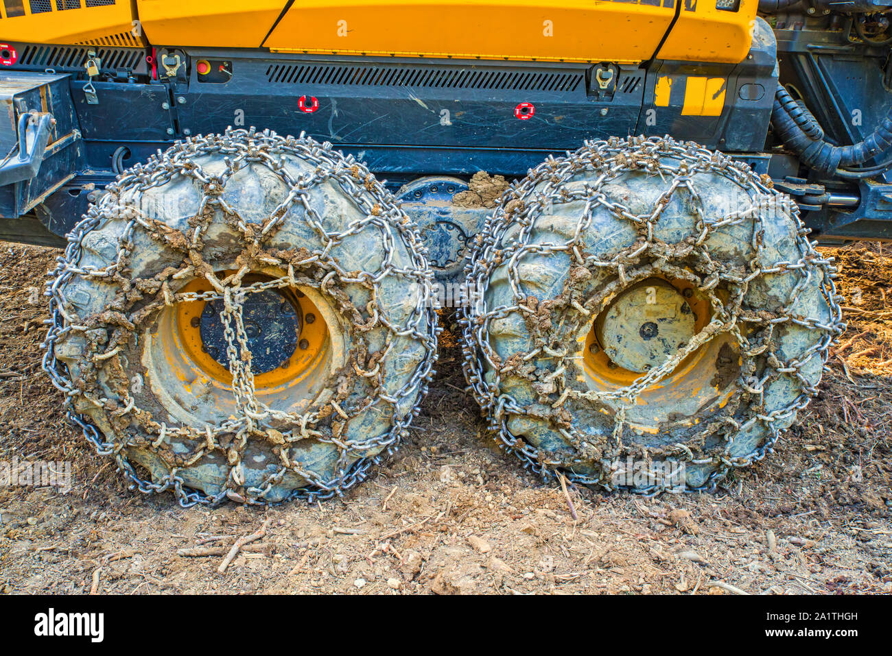 Les roues de la machine d'exploitation forestière équipé de chaînes travaillant dans la forêt Banque D'Images