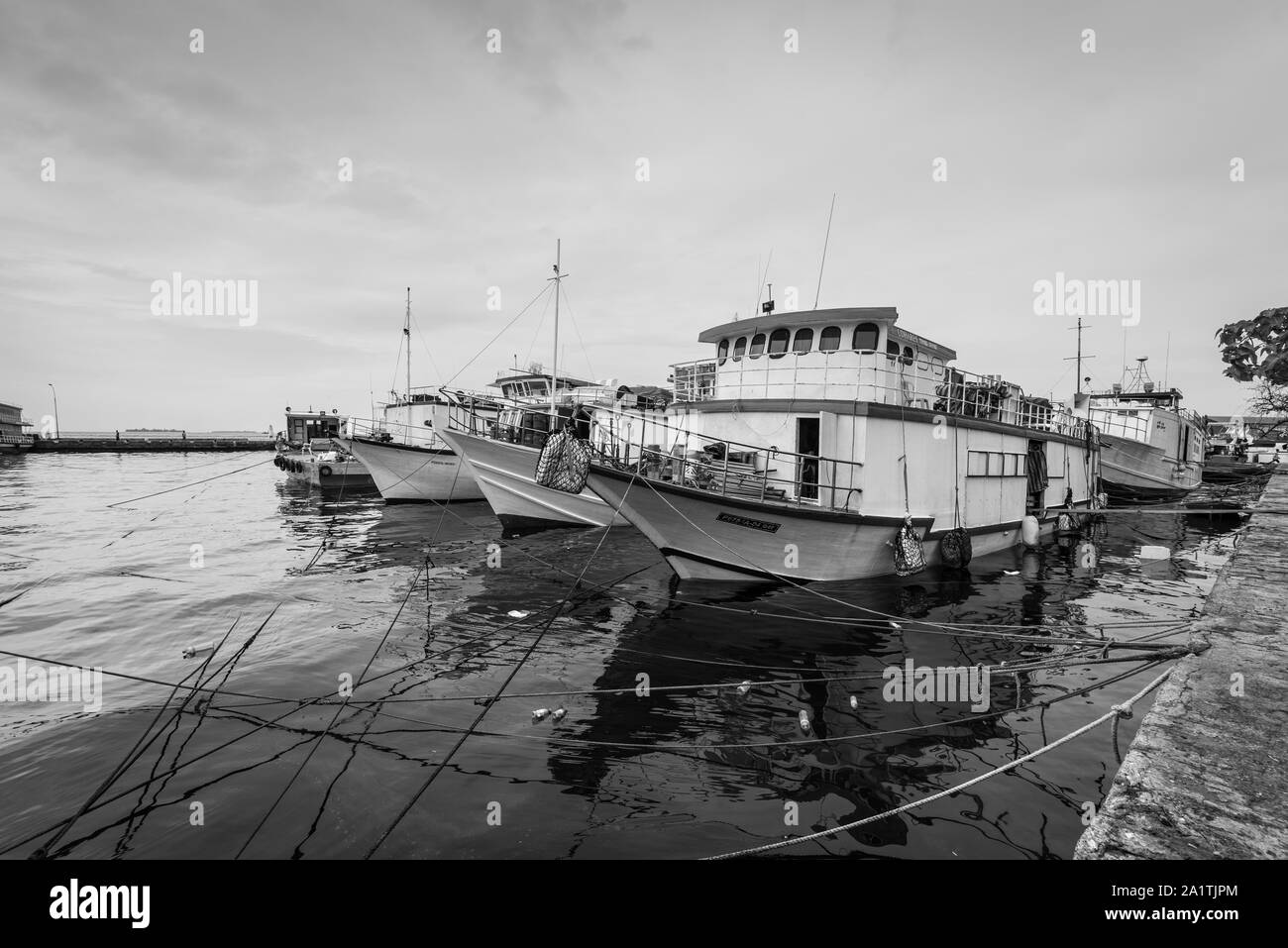 Male, Maldives - Le 16 novembre 2017 : la pêche et le transport des bateaux sont amarrés à la jetée de l'île de mâles dans les Maldives. La photographie en noir et blanc. Banque D'Images