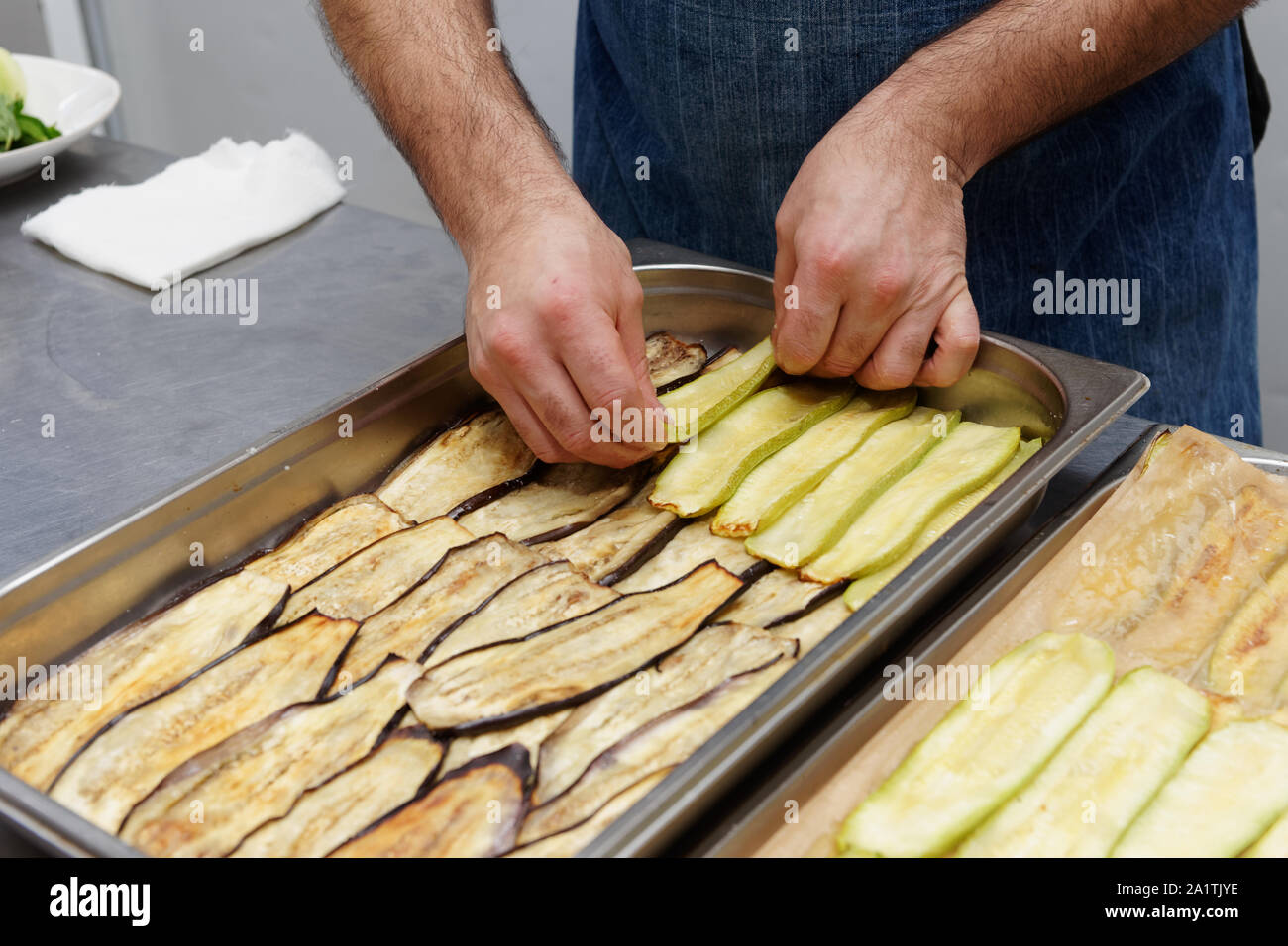 Chef, c'est Définition des couches de légumes à cuisiner la moussaka grecque, cuisine professionnelle Banque D'Images