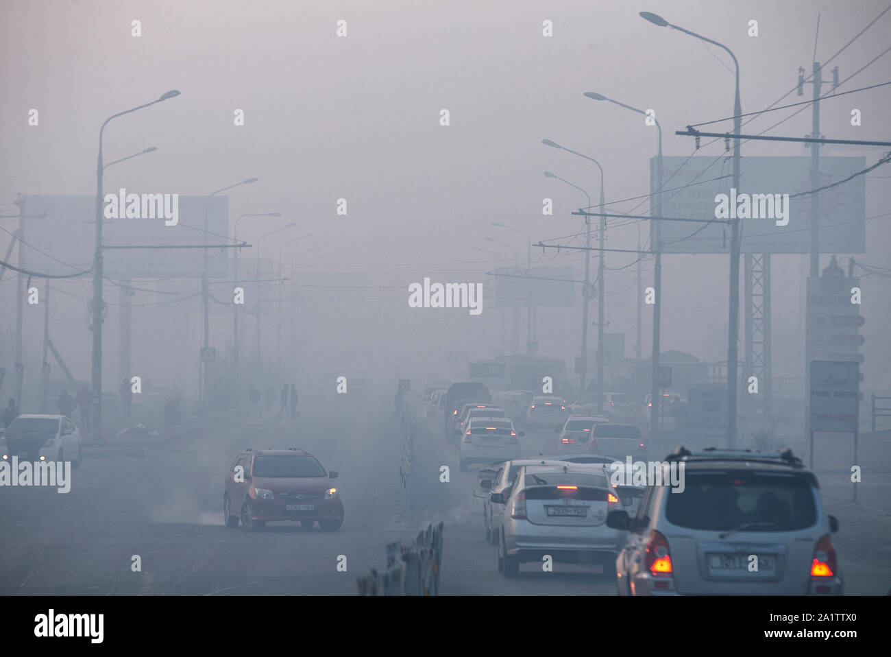 Les voitures roulent à travers la pollution de l'épais à Oulan-Bator, en Mongolie. Banque D'Images