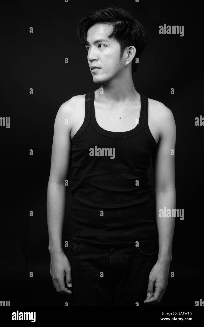 Beau jeune homme asiatique sur fond noir Banque D'Images