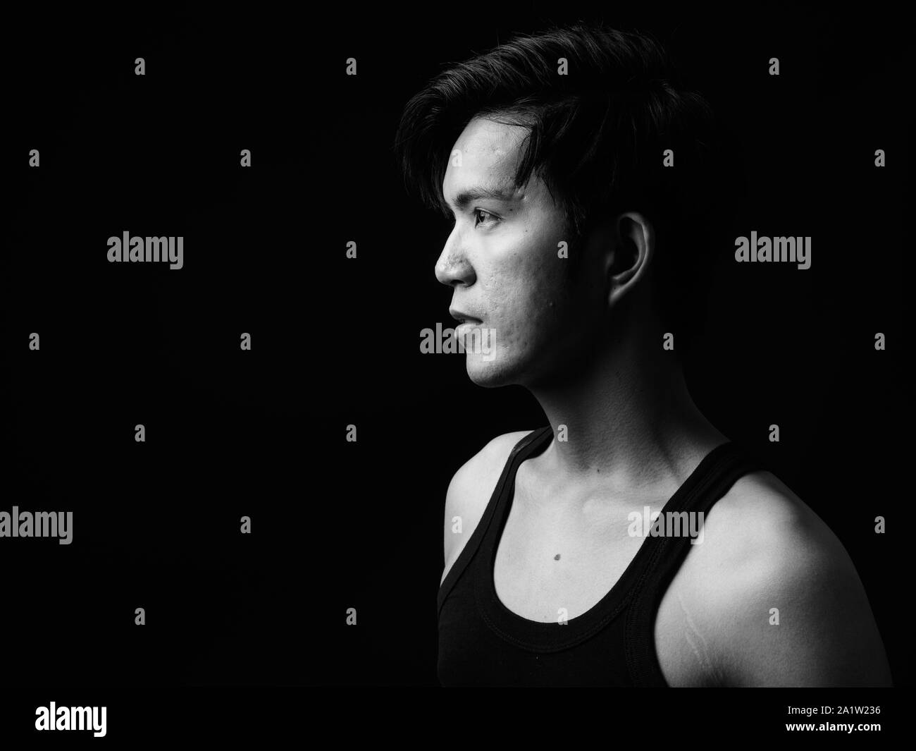 Beau jeune homme asiatique sur fond noir Banque D'Images