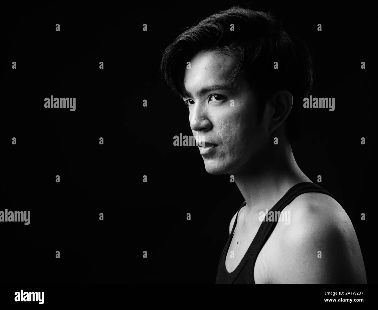 Beau jeune homme asiatique sur fond noir Banque D'Images