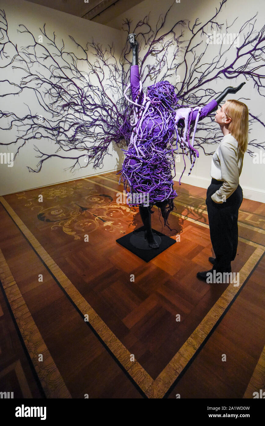 Londres, Royaume-Uni. 29 septembre 2019. Un membre du personnel pose avec 'une scène inversée rétrograder 2', 2013, par Mary Sibande. . Aperçu de "mary Sibande : je suis venu en point', une exposition de l'Afrique du Sud un des artistes éminents humide, Mary Sibande. Sa première exposition solo UK comprenait des photographies et sculptures les représentations stéréotypées de la femme difficile en Afrique du Sud aujourd'hui. Le spectacle est dans le 1-54 avec juste l'Art Contemporain Africain à Somerset House 3 Octobre au 5 janvier 2020. Crédit : Stephen Chung / Alamy Live News Banque D'Images