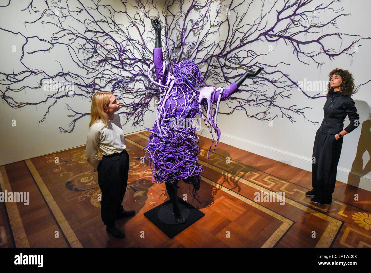 Londres, Royaume-Uni. 29 septembre 2019. Les membres du personnel posent avec 'une scène inversée rétrograder 2', 2013, par Mary Sibande. . Aperçu de "mary Sibande : je suis venu en point', une exposition de l'Afrique du Sud un des artistes éminents humide, Mary Sibande. Sa première exposition solo UK comprenait des photographies et sculptures les représentations stéréotypées de la femme difficile en Afrique du Sud aujourd'hui. Le spectacle est dans le 1-54 avec juste l'Art Contemporain Africain à Somerset House 3 Octobre au 5 janvier 2020. Crédit : Stephen Chung / Alamy Live News Banque D'Images