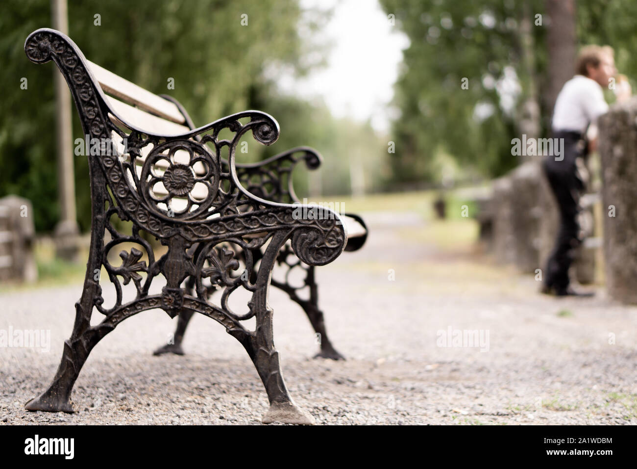 Un banc vide avec un homme de manger de la crème glacée dans l'arrière-plan Banque D'Images