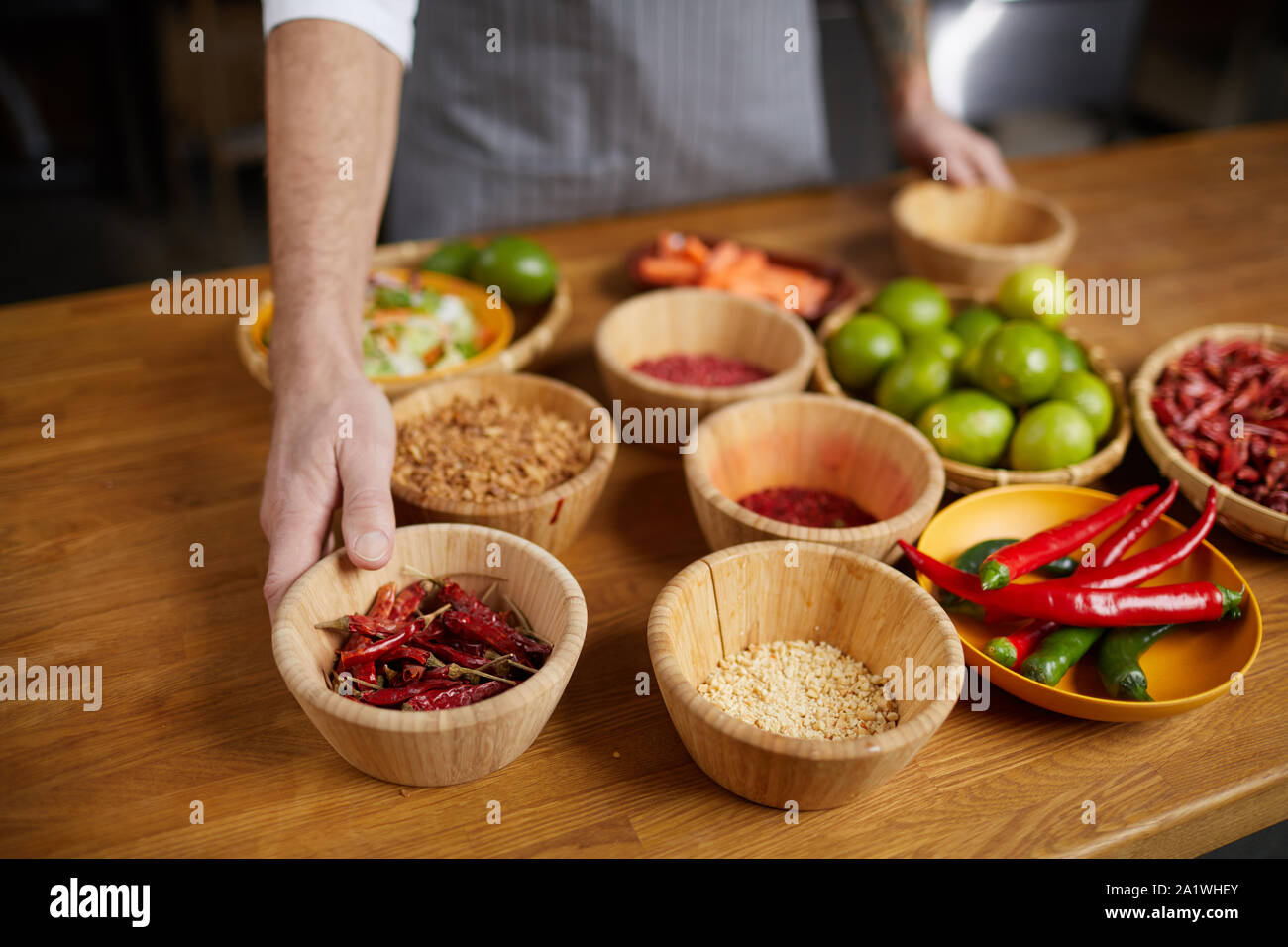 Image de fond de l'établissement chef méconnaissable ingrédients sur table en bois pendant la cuisson d'aliments épicés dans une cuisine de restaurant, copy space Banque D'Images