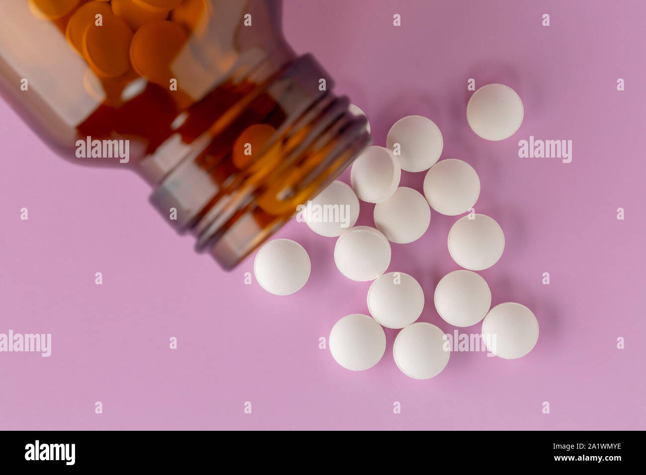 Comprimé rond blanc dispersés en face du verre bouteille de pilules Banque D'Images