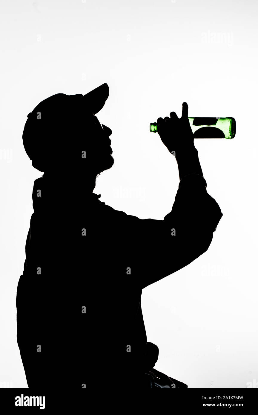 Une silhouette d'hommes qui est la consommation de bière Banque D'Images
