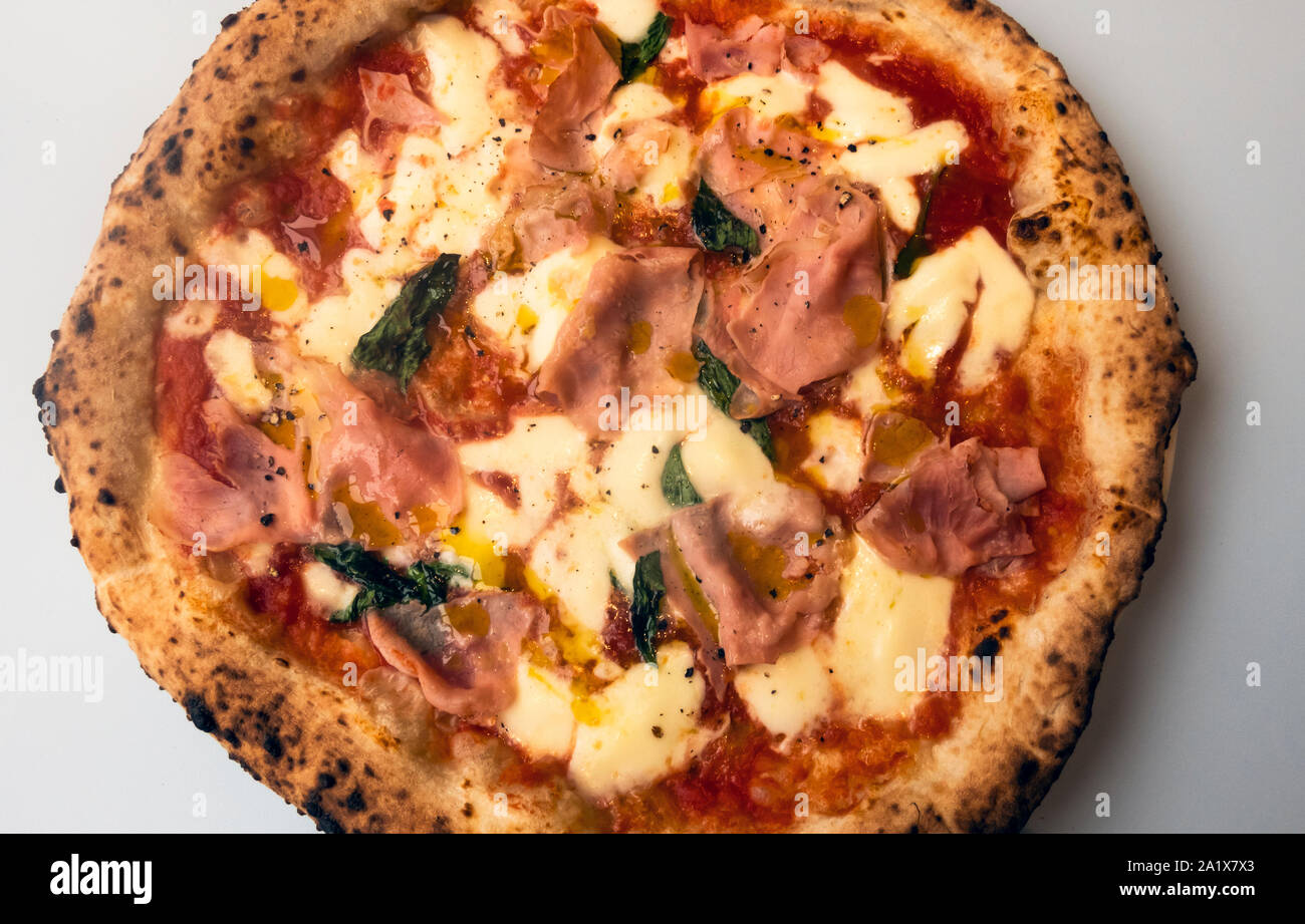 Pizza au jambon, mozzarella, tomates et basilic Banque D'Images