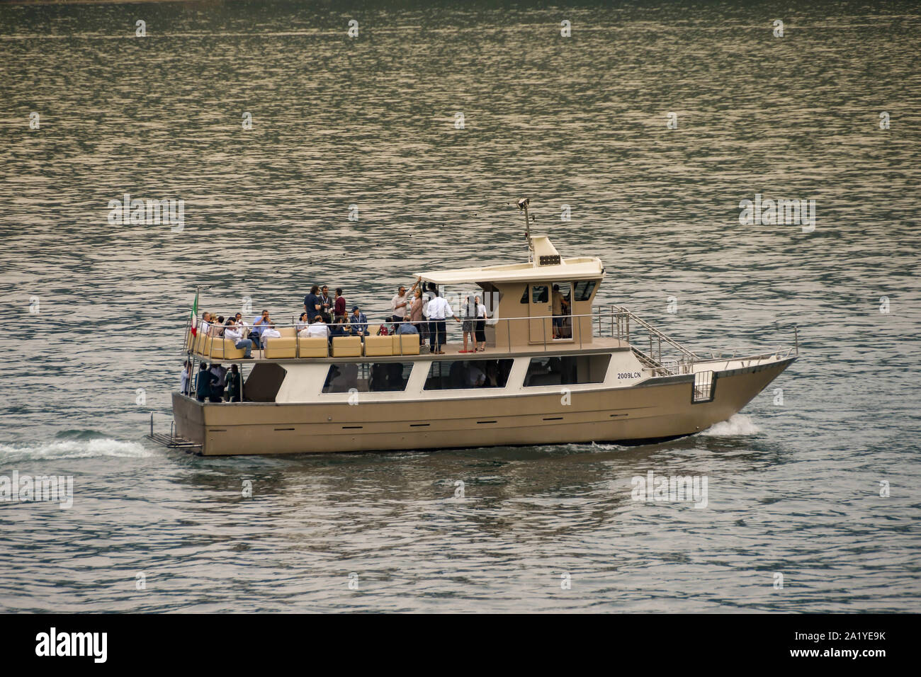 Le lac de Côme, Italie - Juin 2019 : un bateau à moteur sur le lac de Côme avec les gens à un événement social sur ses ponts. Banque D'Images