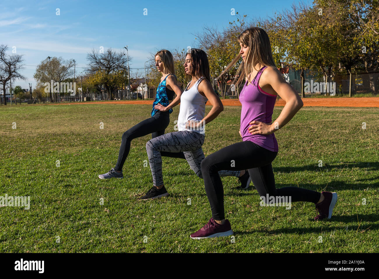 Trois femmes de race blanche dans le parc, deux blondes et une brune entraîner dans le parc. Le sport, la santé et le style de concept Banque D'Images