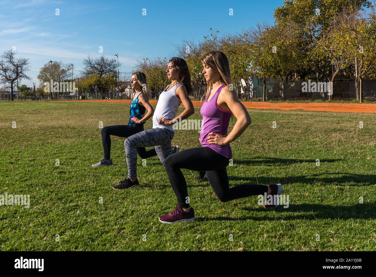 Trois femmes de race blanche dans le parc, deux blondes et une brune entraîner dans le parc. Le sport, la santé et le style de concept Banque D'Images