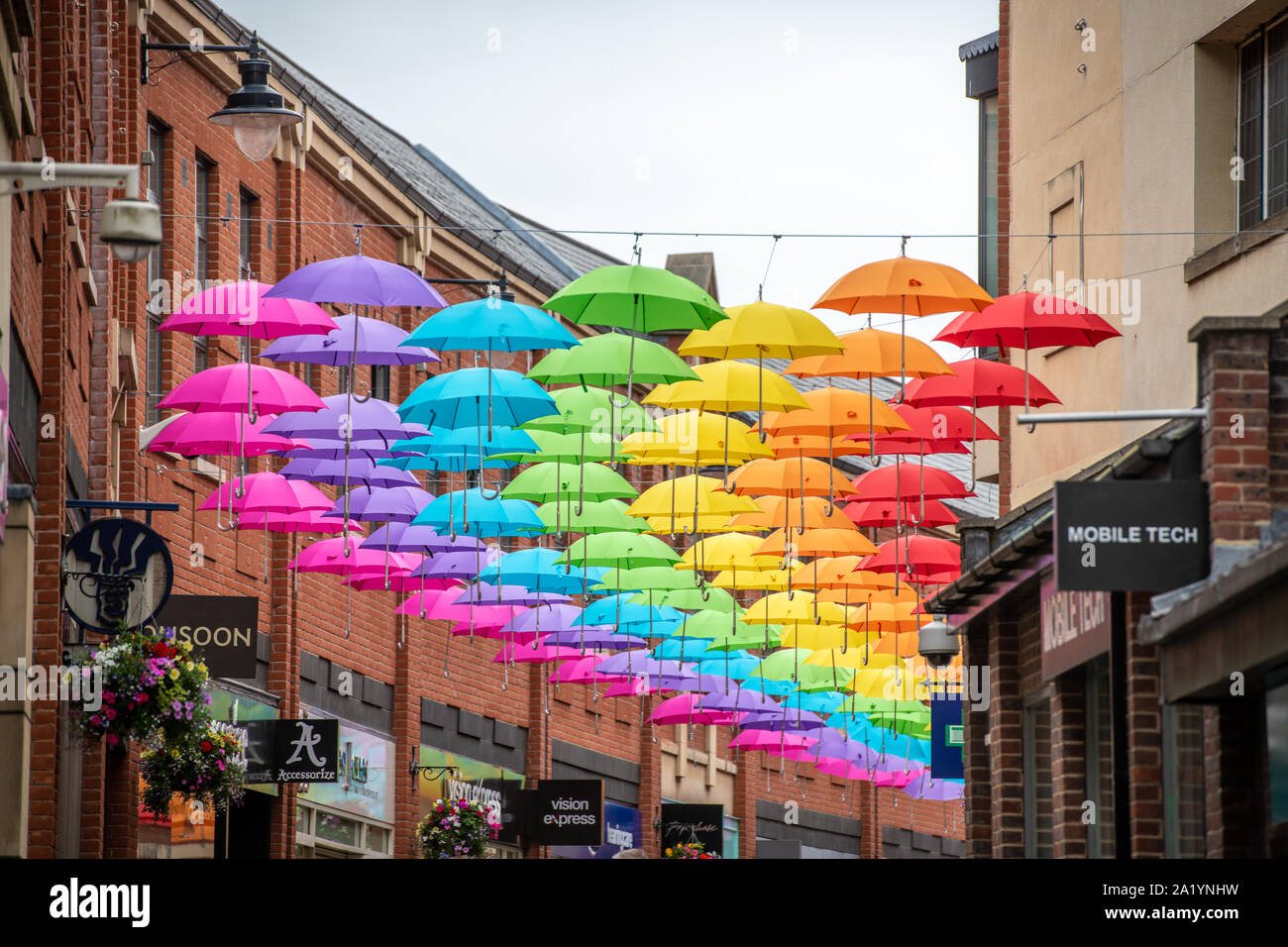 Une série de parapluies arc-en-ciel qui pèsent sur une rue latérale, Durham UK Banque D'Images