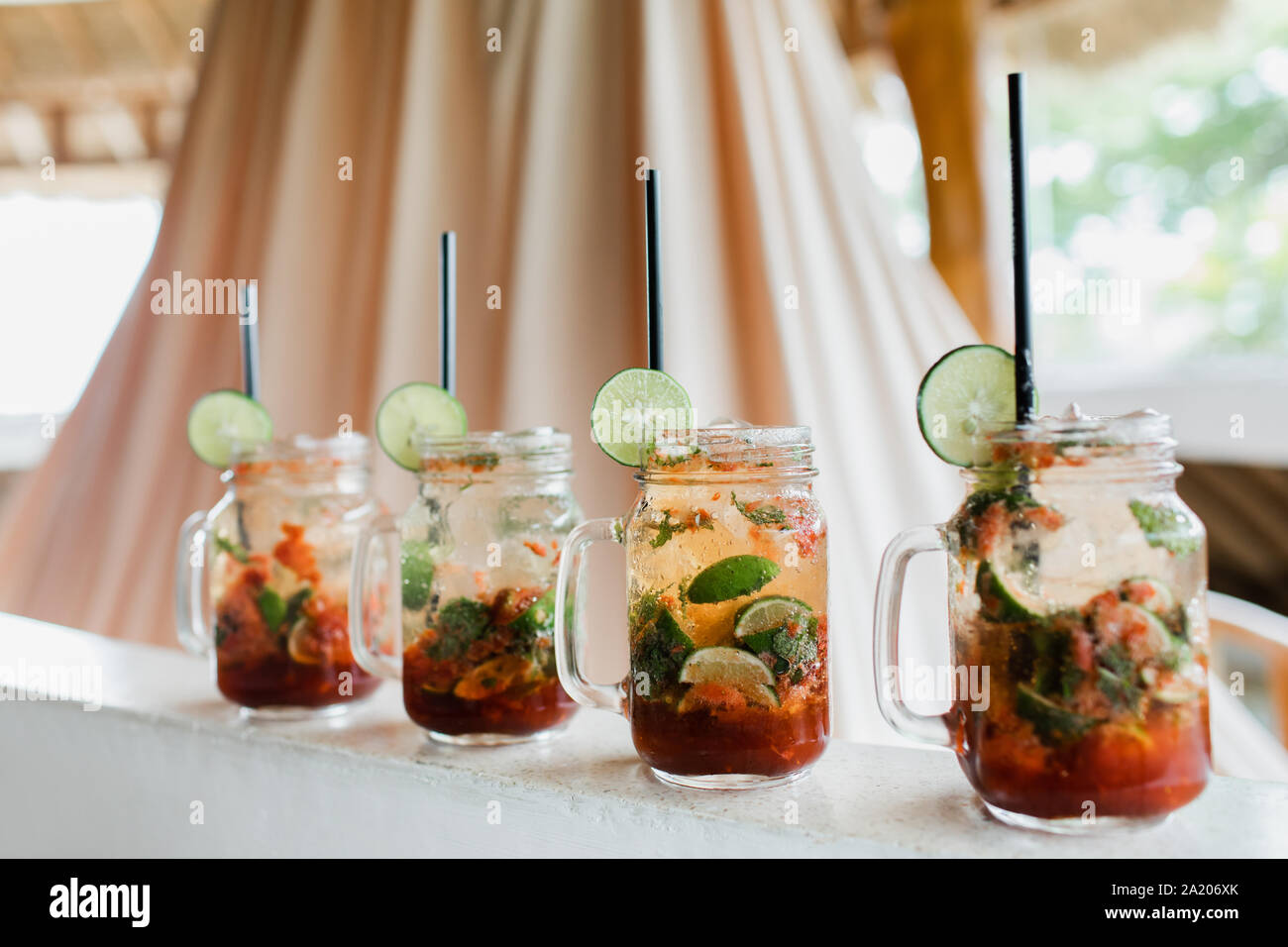 Ensemble de quatre cocktails mojito. Tranche de lime, bouteille de verre, la paille noire. Boisson froide en été, vacances concept. Banque D'Images