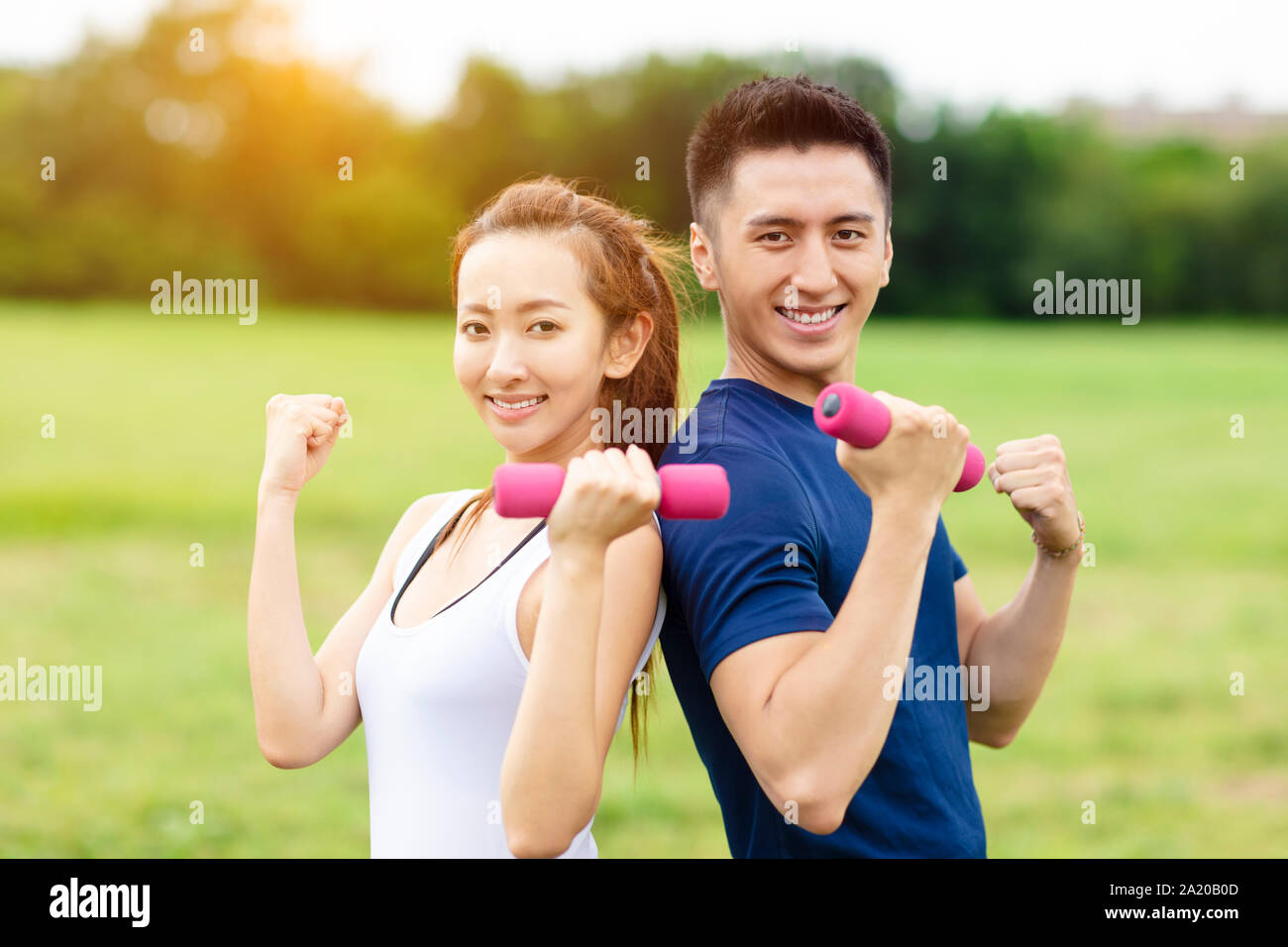 Jeune couple asiatique avec haltères d'entraînement Banque D'Images