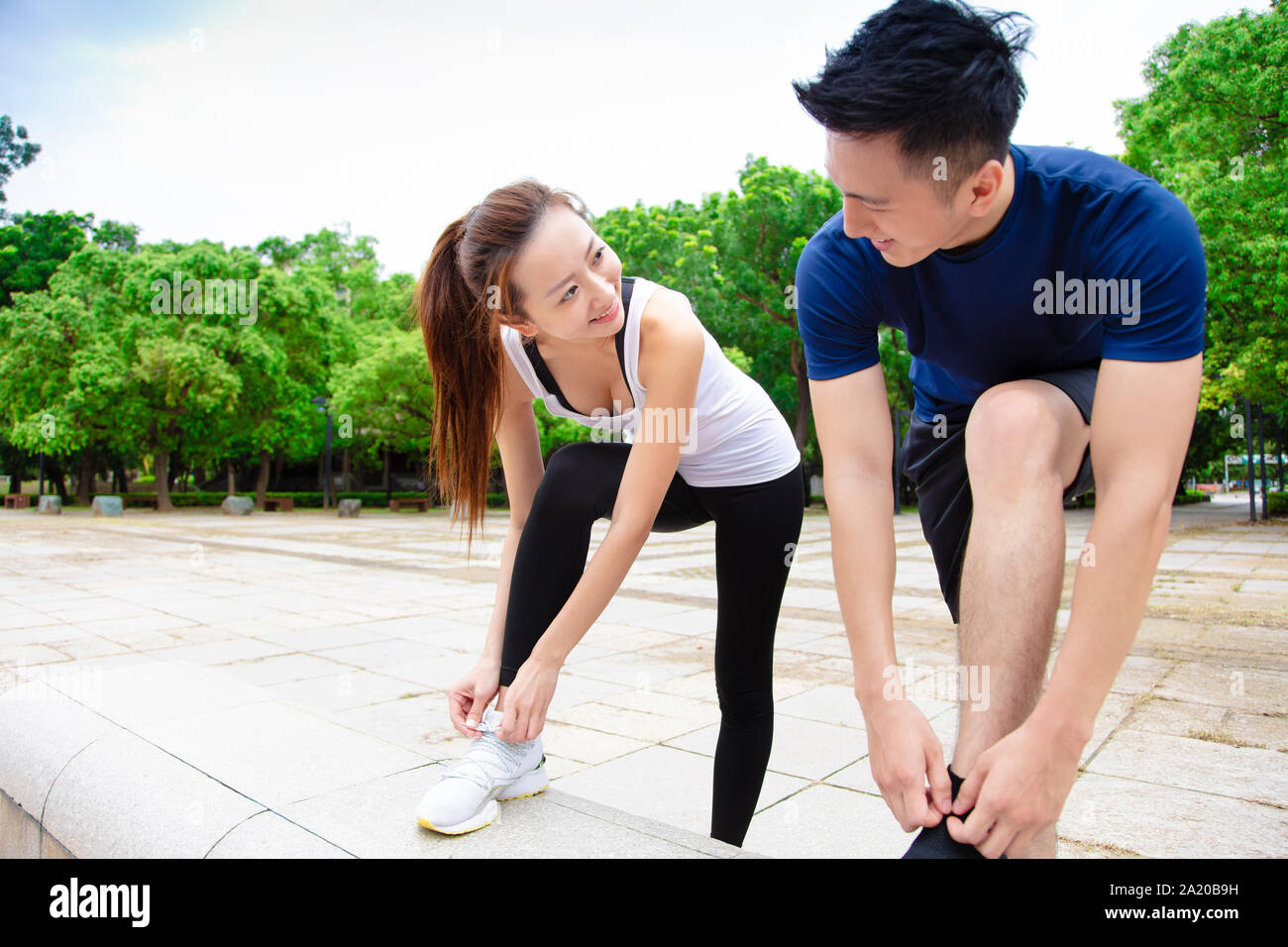 Jeune couple attachant des chaussures de course et s'apprête à exécuter Banque D'Images