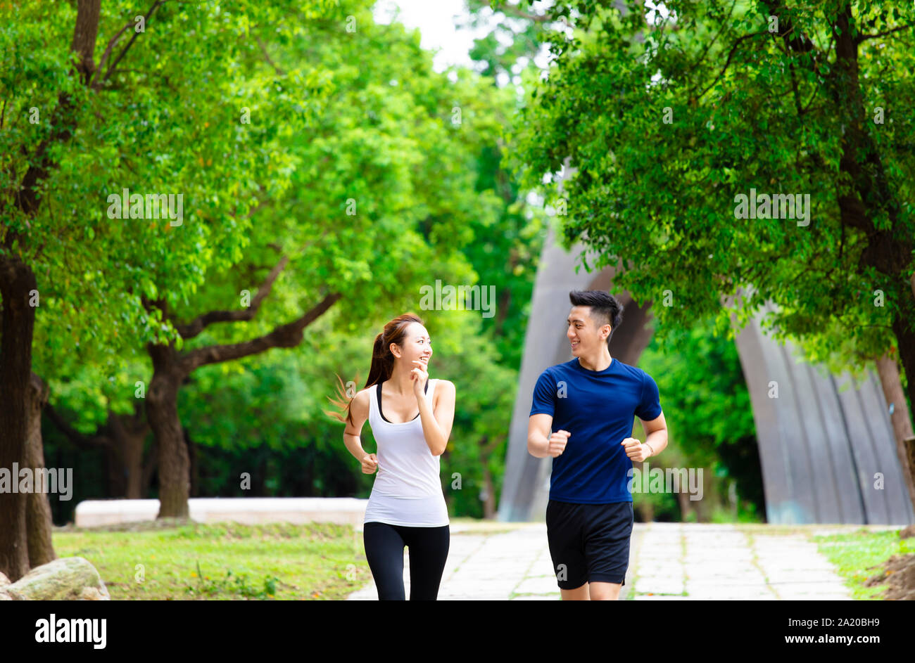 Heureux Couple jogging et d'exécution en nature Banque D'Images