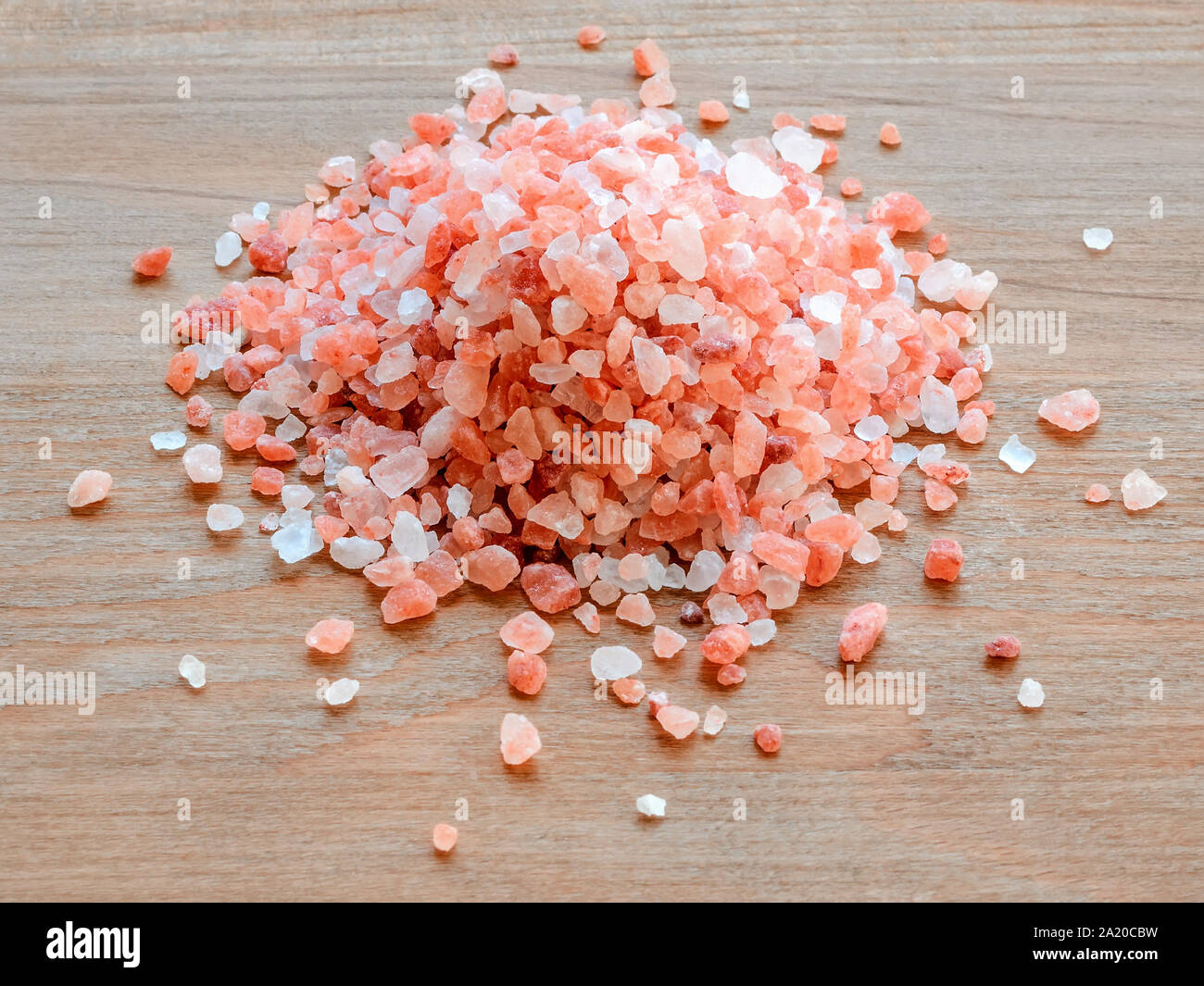 Tas de cristaux de sel de l'himalaya rose sur un fond en bois brun. Sel de l'Himalaya est utilisé en cuisine, en médecine et en cosmétologie. Vue de face. Banque D'Images