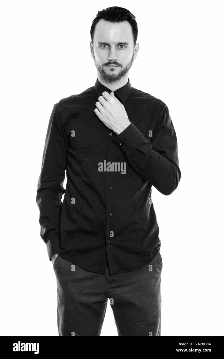 Portrait de jeune homme debout tout en fixant son col Banque D'Images Portrait de jeune homme debout tout en fixant son col Banque D'Images