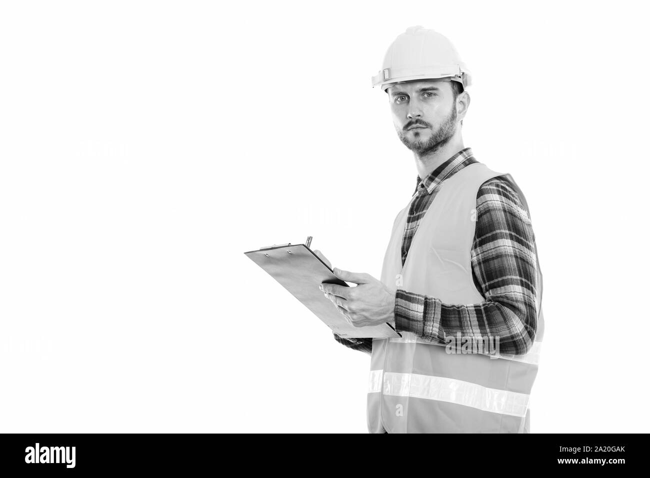 Portrait de jeune homme construction worker writing on clipboard Banque D'Images