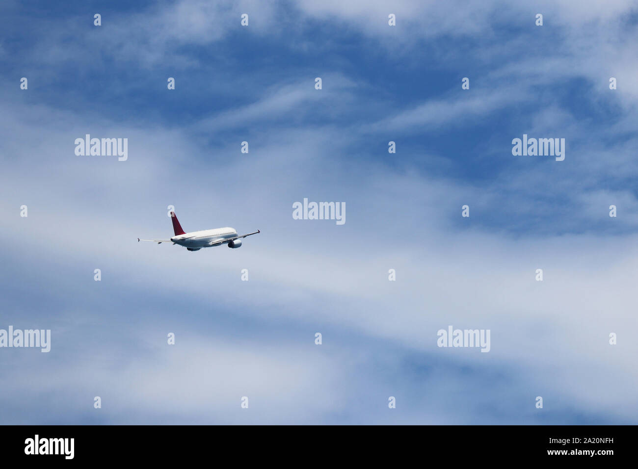Vol d'un avion dans le ciel bleu sur fond de nuages blancs, vue arrière. Moteur deux-avion commercial pendant le virage, la turbulence et le concept de voyage Banque D'Images