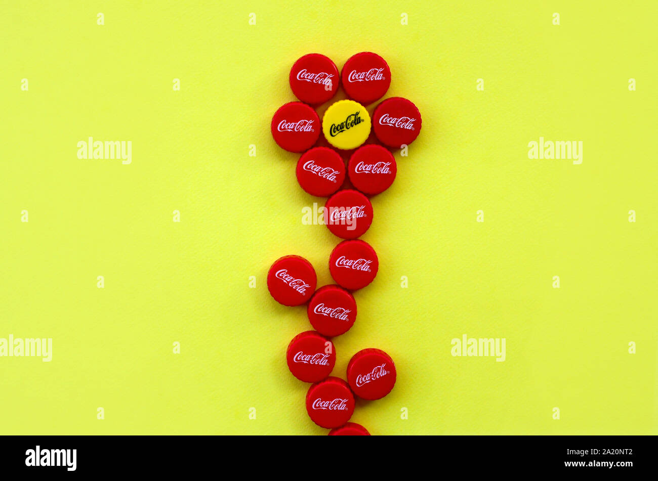 KHARKOV, UKRAINE - septembre 8, 2019 : Fleur de nombreux red caps avec coca cola logo sur fond jaune. Le Coca-Cola est un célèbre dans le monde entier sans alcool Banque D'Images