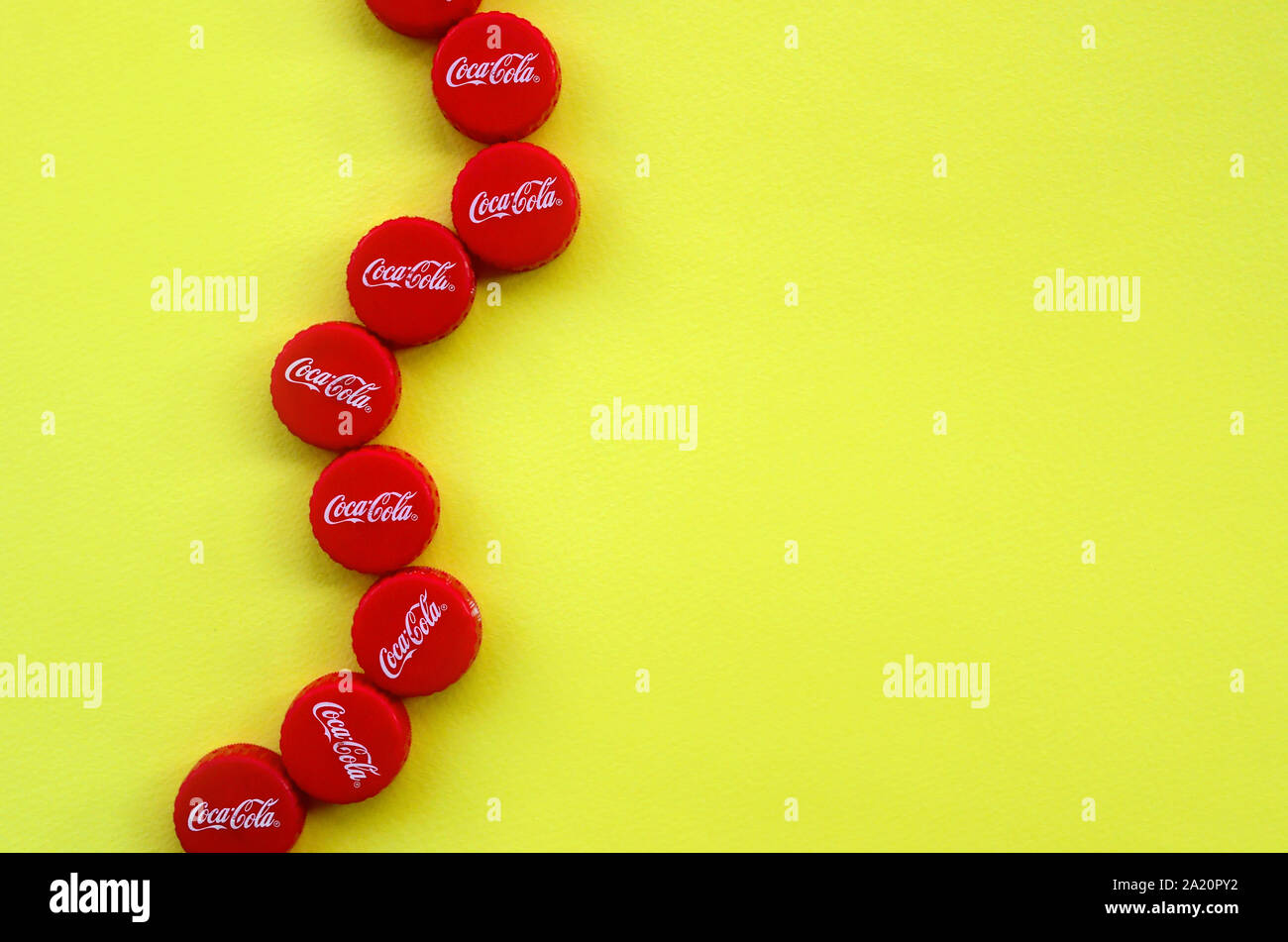 KHARKOV, UKRAINE - 8 septembre 2019 : de nombreux red caps avec coca cola logo sur fond jaune. Le Coca-Cola est une boisson sans alcool célèbre d Banque D'Images