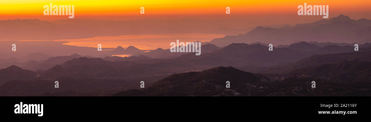 Panorama du lac de Skadar au Monténégro durant le lever du soleil sur un beau matin brumeux. Montagnes qui entourent le lac visible Banque D'Images