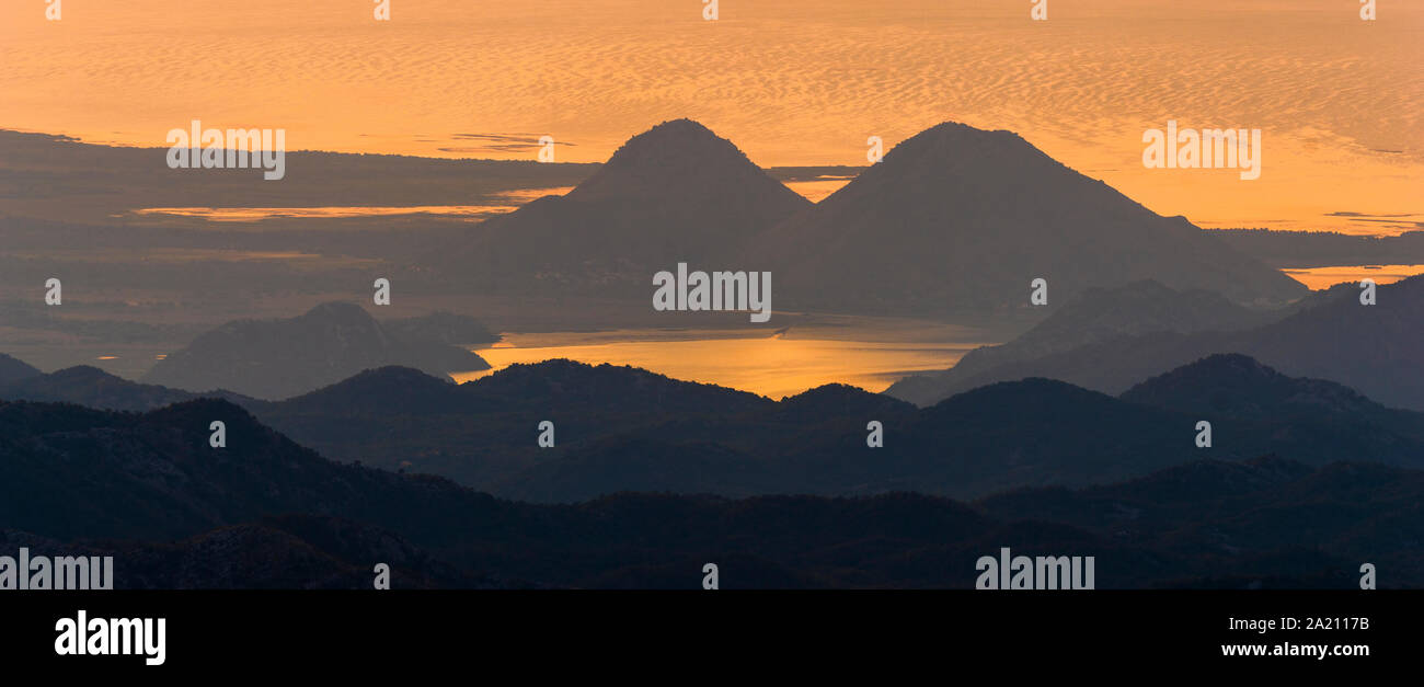 Panorama du lac de Skadar au Monténégro durant le lever du soleil sur un beau matin brumeux. Montagnes qui entourent le lac visible Banque D'Images