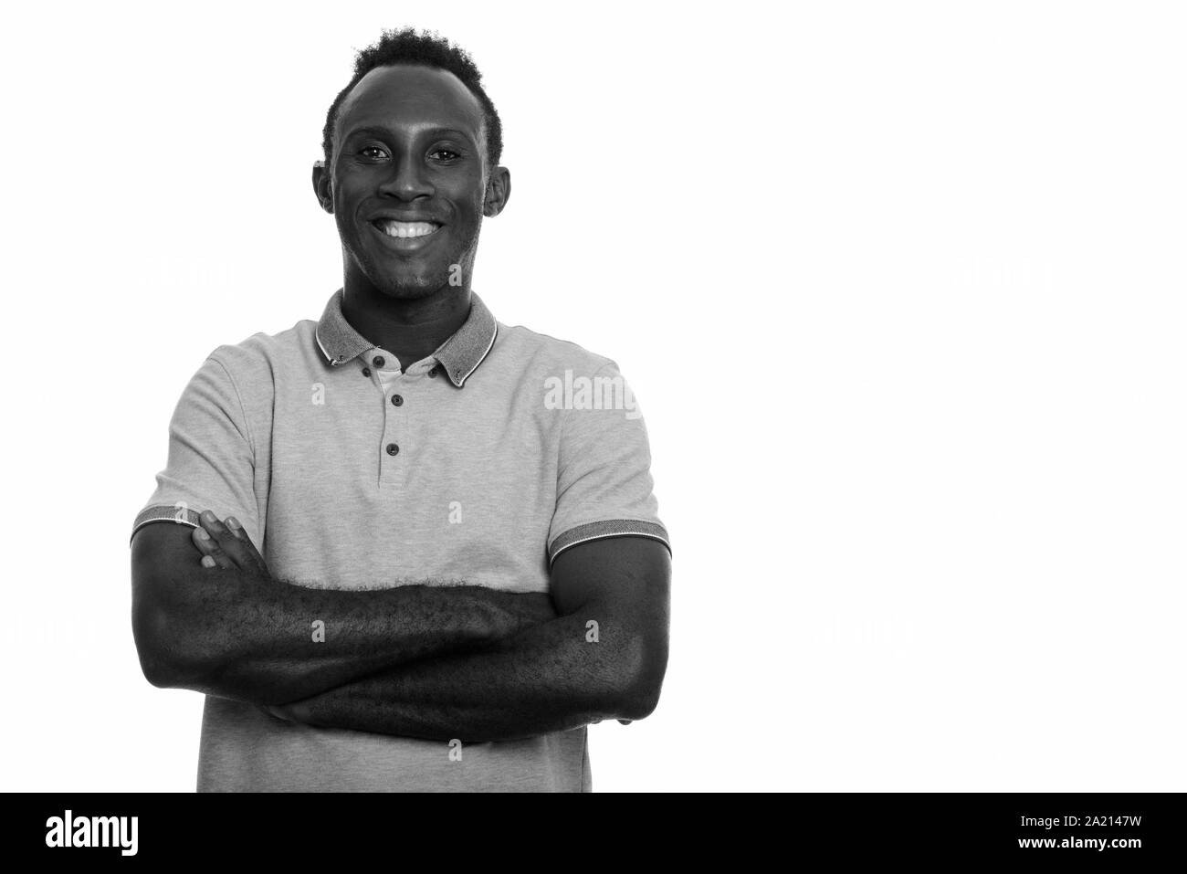 Young happy black African man smiling with arms crossed Banque D'Images