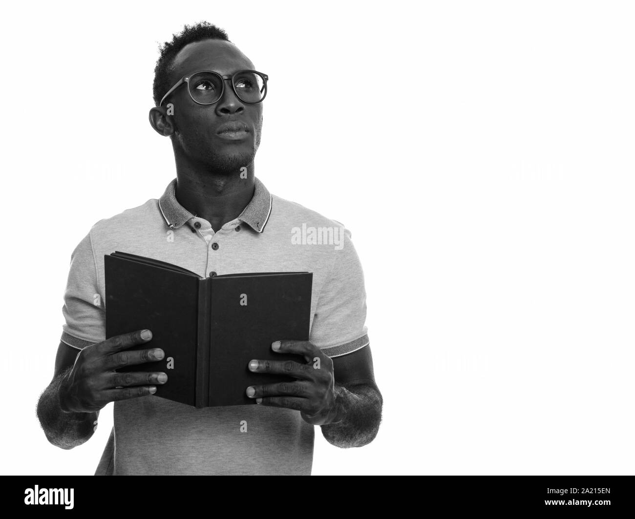 Young black African man holding book en pensant Banque D'Images