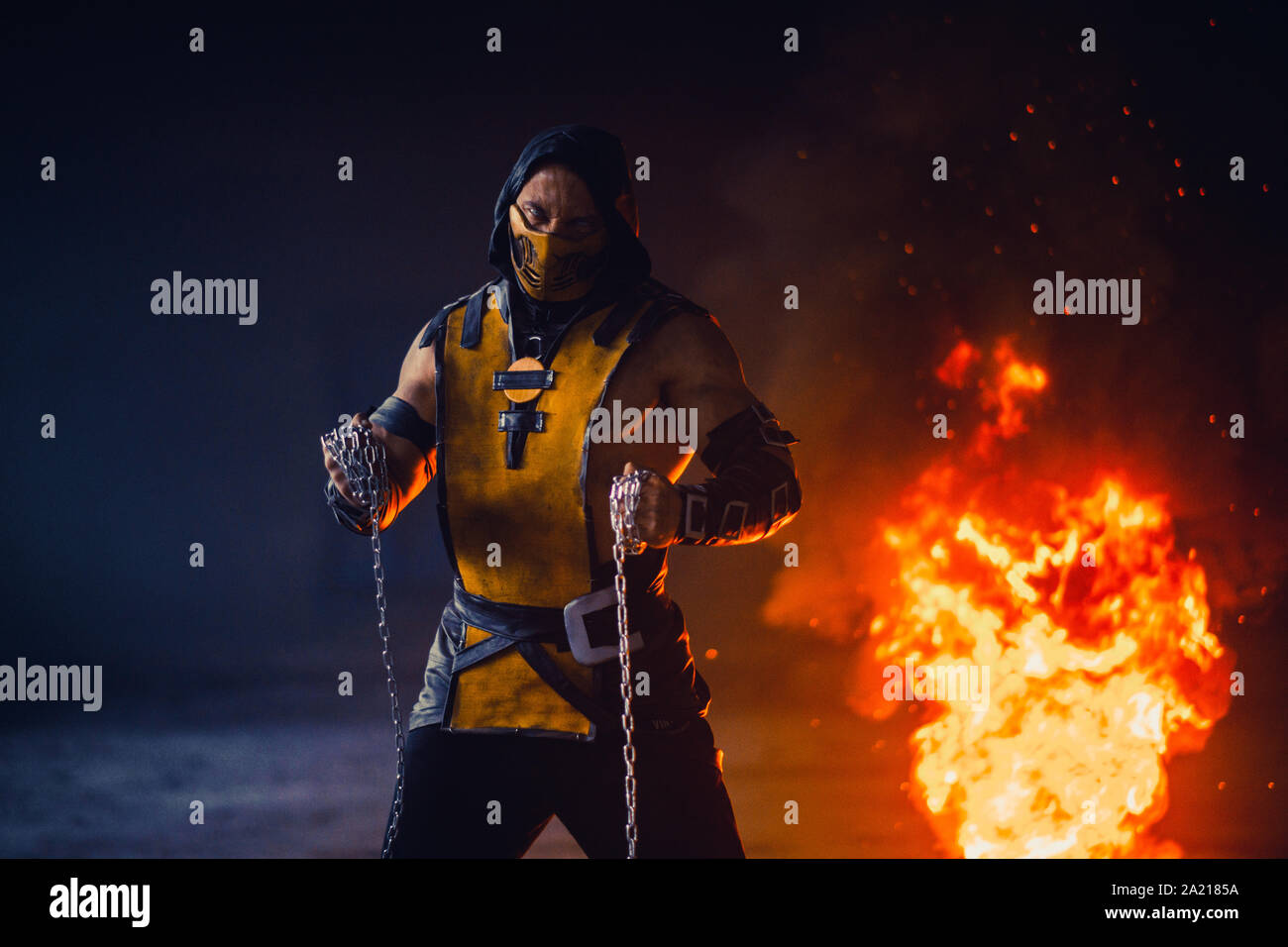 Le portrait de l'homme Scorpion guerrier avec des chaînes dans ses mains  pose à l'arrière-plan d'incendie et de fumée Photo Stock - Alamy