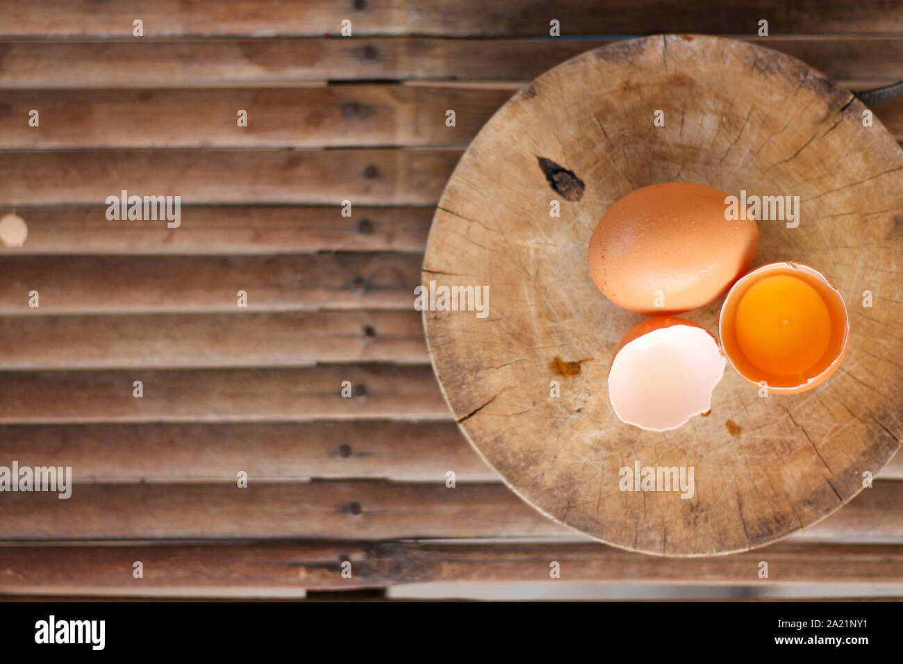 Les oeufs bruns sur une planche à découper en bois il y a un œuf dans la coquille de l'oeuf. Le brown egg a une goutte d'eau parce que c'est la dépose du réfrigérateur Banque D'Images