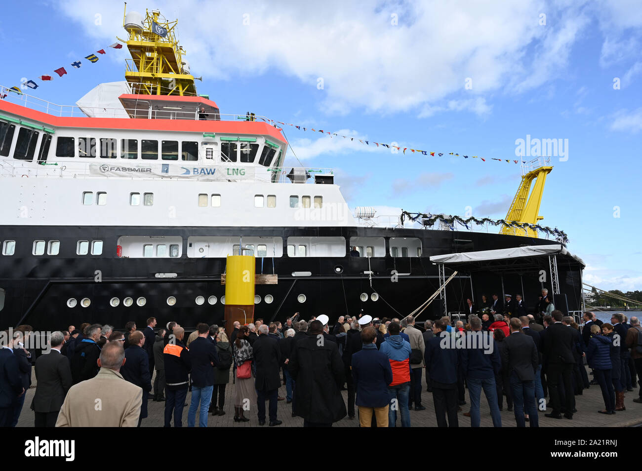 30 septembre 2019, Basse-Saxe, Berne : de nombreux invités se tenir en face du navire au chantier naval Fassmer au baptême du 'Atair'. L'avenir l'arpentage, l'épave du navire de recherche et de recherche a été construit pour l'agence fédérale maritime et hydrographique (BSH). Avec une longueur de 75 mètres, la construction de 114 millions d'euros est le plus grand navire de BSH date. Photo : Carmen Jaspersen/dpa Banque D'Images